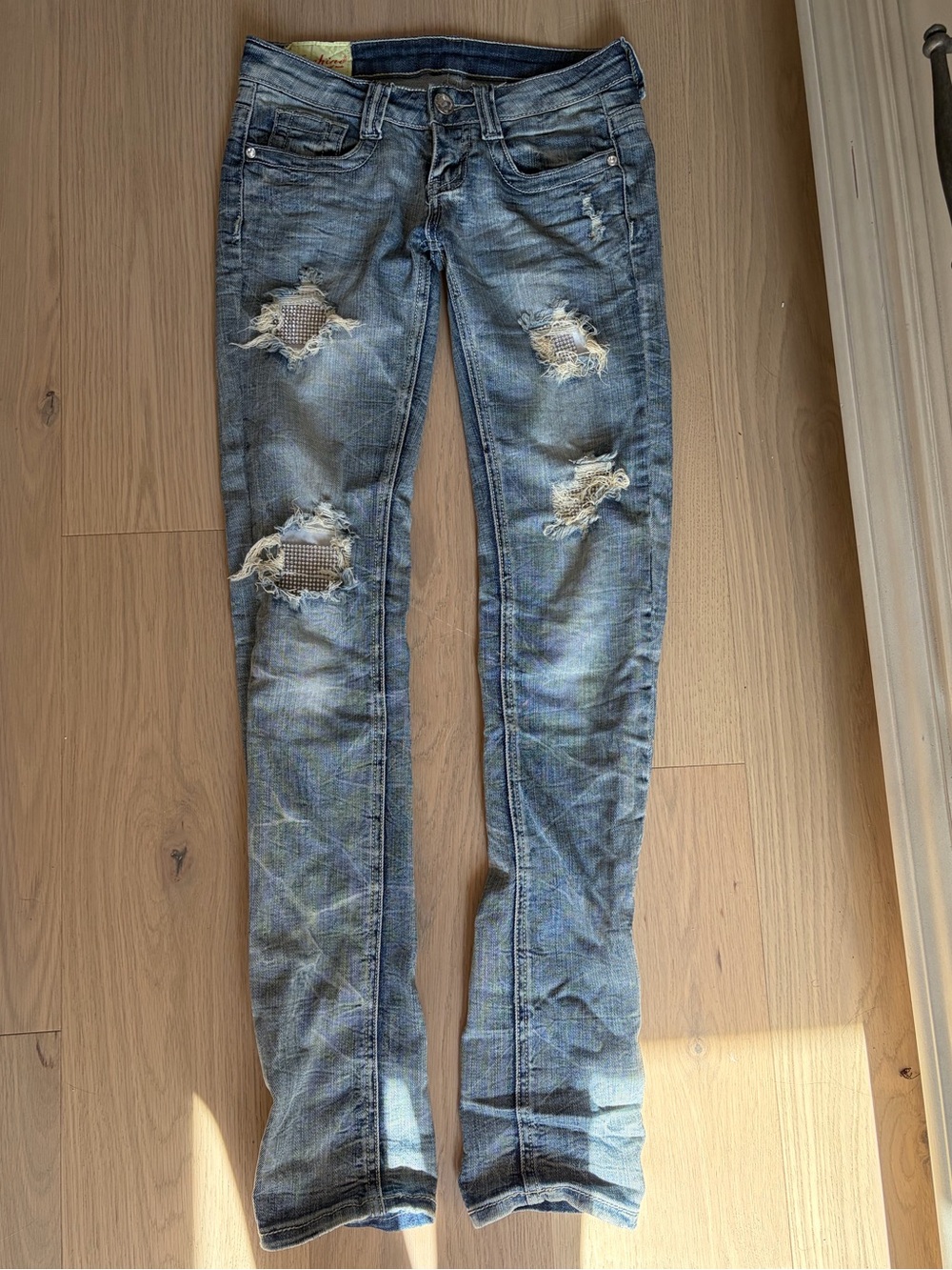 Machine distressed crystal embellished low rise denim jeans